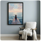 Framed black cat sitting on wooden dock at sunset wall art displayed beside white linen armchair with throw blanket in serene light blue reading nook