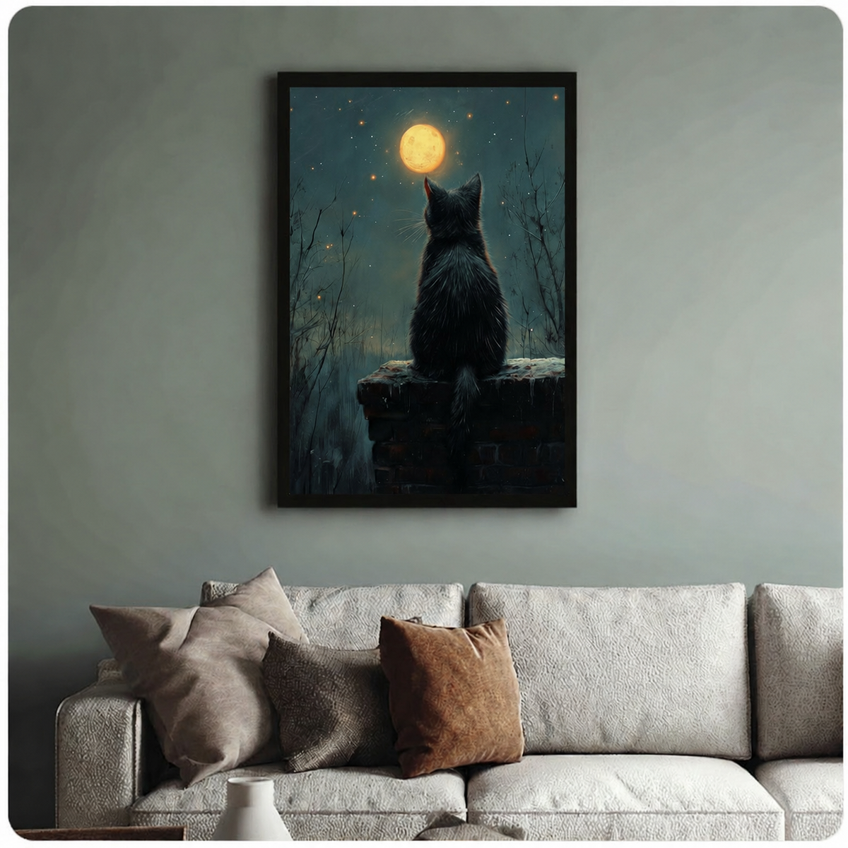 Black framed canvas art of a mysterious cat gazing at the moon at night, hung above a neutral sofa on a sage green wall