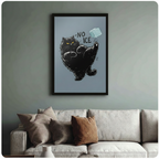 Black cat kicking ice cube framed poster art hanging above a sage green sofa in a cozy living room
