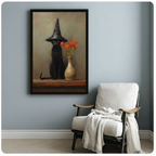 Vertical framed canvas of a brooding black cat in a witch hat with an orange floral vase, hung beside a white armchair in a cozy reading nook