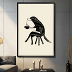 Framed minimalist black and white ink art print of an anthropomorphic dog sitting on a stool holding a steaming coffee cup, displayed in a dark modern living room with candlestick decor