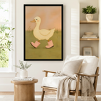 Large framed art print featuring a charming white duck in pink rain boots on a warm earthy background, styled beside a linen armchair and round wood side table in a Boho reading corner