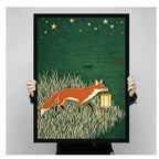 Close-up of framed fox and lantern wall art print held by hands, showing detailed woodblock-style illustration