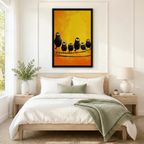 Black framed funny black birds on a wire canvas art with five fluffy shaggy black birds with wide cartoon eyes in varying sizes perched together on a thin wire against a glowing amber and golden yellow painterly background, hung above a light wood bed with white linen bedding and a sage green throw in a serene Scandinavian bedroom