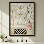 Funny white goose in pink shower cap bathroom illustration in black frame above a white bathroom sink with black faucet, soap dispenser, and small potted plant on a white marble countertop