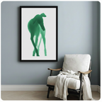 Framed abstract green greyhound art print hanging above white armchair on blue-grey wall – elegant minimalist dog wall decor