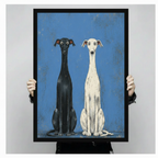 Framed greyhound duo canvas art held up close showing black wood frame depth and print detail