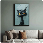 Framed whimsical black cat art print with disheveled fur and bold yellow eyes hung above a cream textured sofa in a sage green living room