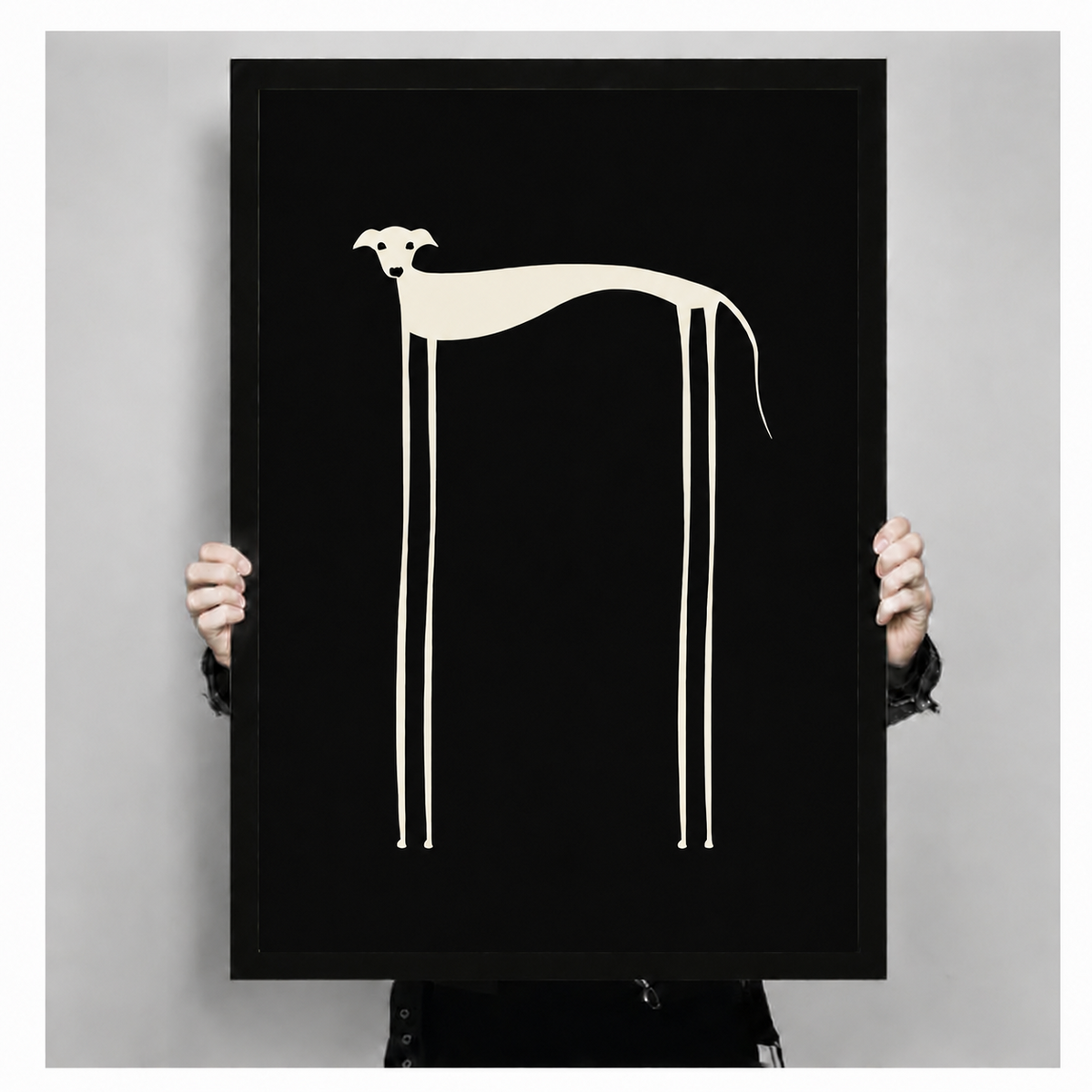 Hand-held front view of minimalist long-legged dog poster in black frame on white background