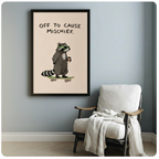 Black framed raccoon mischief poster print hung on a blue-grey wall above a linen armchair, funny animal art for living room or bedroom decor