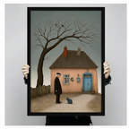 Person holding large framed melancholic narrative oil painting old man in black coat standing before pink cottage gazing at blue-grey cat canvas print with both hands - close up view of moody bare tree with crows rustic fence and muted teal sky wall art with black frame finish
