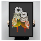Person holding large framed owl duo canvas wall art — folk art owl print size reference, bold charcoal background with amber and orange feather tones