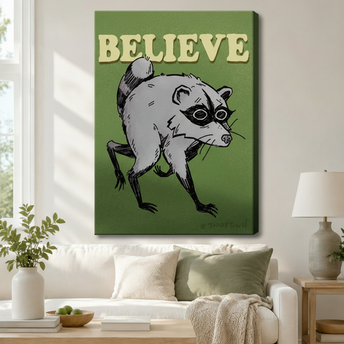Stretched canvas retro funny Believe raccoon wall art featuring a sketchy gray raccoon with a black eye mask in a low crouching stance with bold cream Believe lettering at the top on a deep olive green background, hung above a white sofa with sage green pillows in a bright living room