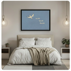 Black framed funny seagull Hide Your Fries coastal quote canvas wall art hung above a beige upholstered bed with white linen bedding in a minimalist bedroom with glass globe pendant lights and potted plants