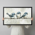 Three chubby blue birds on a wire watercolour framed print held up against a light gray background, showing print size and frame detail